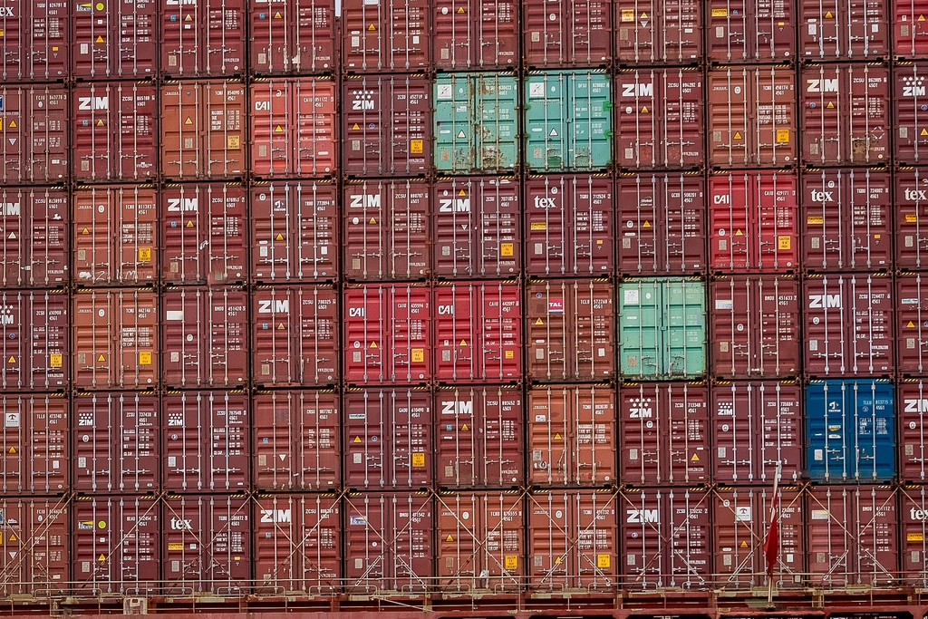 A dense wall of stacked shipping containers